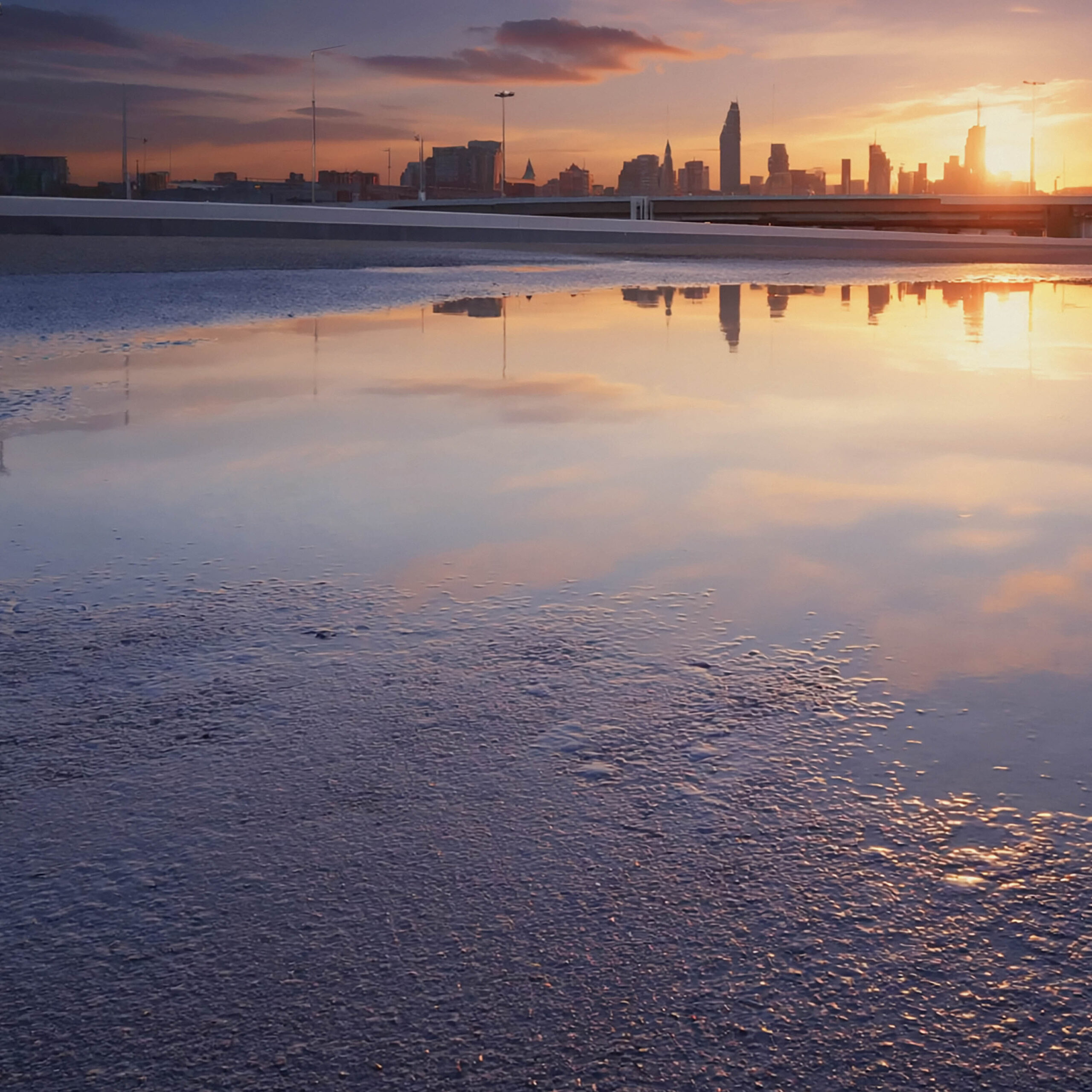 夕焼けの都市と水面に映る静かなリフレクション風景
